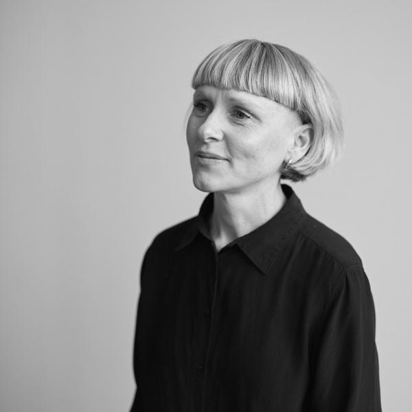 A black and white photo of a person in a black blouse.